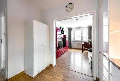 a hallway with a living room with a clock on the wall at Apartment BLUE PEARL 2 rooms Down Town 4 persons balcony free parking in Kraków