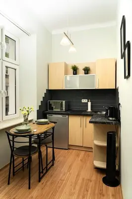 a kitchen with a table and a table and chairs at Studio Asnyka Old Town in Kraków