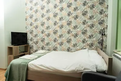 a bed in a room with a wall at Studio Asnyka Old Town in Kraków
