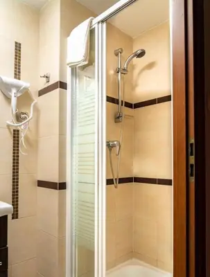 a shower with a glass door in a bathroom at Studio Asnyka Old Town in Kraków