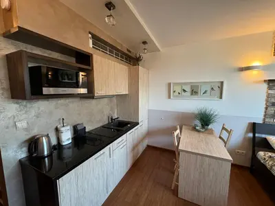a kitchen with a counter top and a table at Stylowe studio z parkingiem - 3 minuty od Dworca & Galerii Krakowskiej in Kraków
