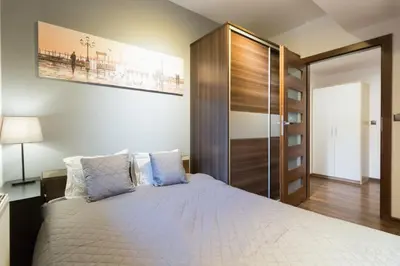 a bedroom with a large bed with blue pillows at Romanowicza 5 Serene Place in Kraków