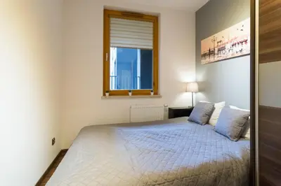 a bedroom with a bed and a window at Romanowicza 5 Serene Place in Kraków