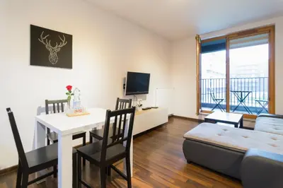 a living room with a table and a couch and a dining room at Romanowicza 5 Serene Place in Kraków