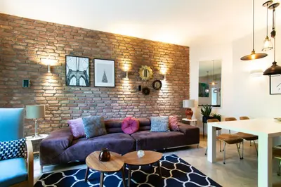 a living room with a couch and a brick wall at Spacious 3BR apartment with AC in living room, 2 balconies in Kraków