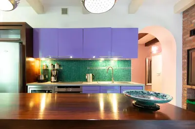 a kitchen with purple cabinets and a wooden table at Spacious 3BR apartment with AC in living room, 2 balconies in Kraków