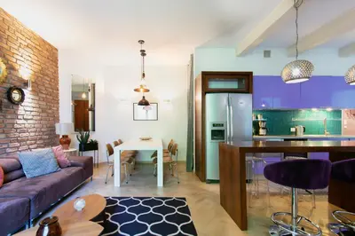 a living room and kitchen with a couch and a table at Spacious 3BR apartment with AC in living room, 2 balconies in Kraków