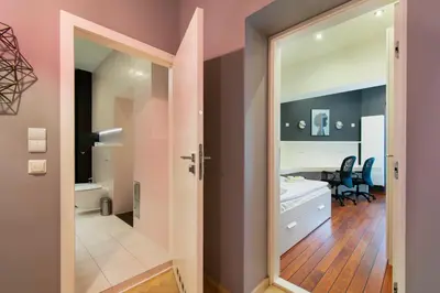 a bathroom with a door leading to a bedroom at Spacious 3BR apartment with AC in living room, 2 balconies in Kraków