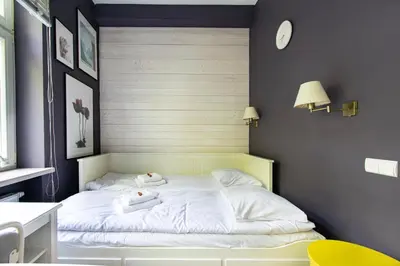 a bedroom with a white bed with two towels on it at Spacious 3BR apartment with AC in living room, 2 balconies in Kraków