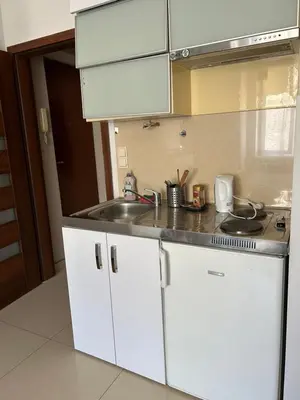 a kitchen with white cabinets and a sink at KR Apartament in Kraków