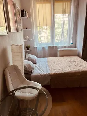 a bedroom with a bed and a chair and a window at KR Apartament in Kraków