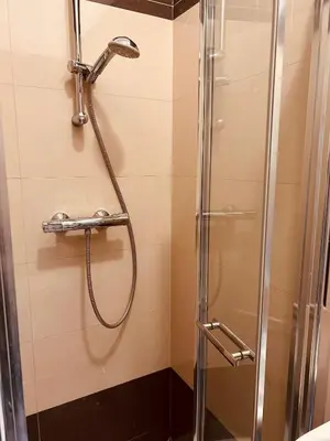 a shower with a glass door in a bathroom at KR Apartament in Kraków