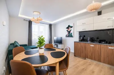 a living room with a flat screen tv on a white cabinet at Apartament Na Szlaku WAWELOFTS in Kraków