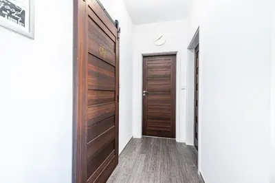 a hallway with a wooden door in a house at Cracovia Apartment in Kraków