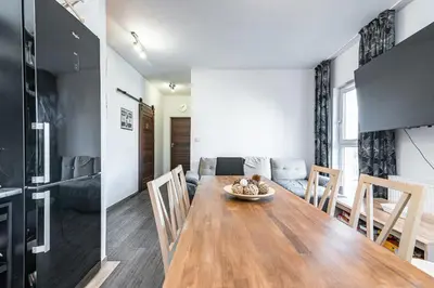 a dining room and living room with a table and chairs at Cracovia Apartment in Kraków
