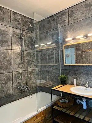 a bathroom with a shower and a tub and a sink at Cracovia Apartment in Kraków