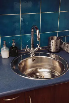 a sink in a kitchen with a blue tiled wall at Kraków Wawel Zwierzyniecka in Kraków