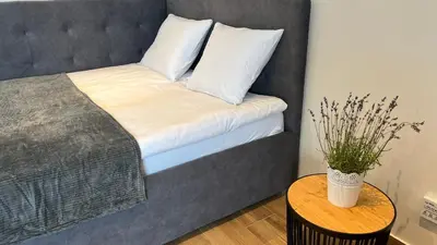 a bed with white pillows and a vase on a table at Rising Sun 3 by Housine,pl in Zator