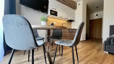 a kitchen with a wooden table and four chairs at Rising Sun 3 by Housine,pl in Zator