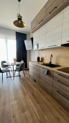 a kitchen with wooden cabinets and a table with a sink at Rising Sun 3 by Housine,pl in Zator
