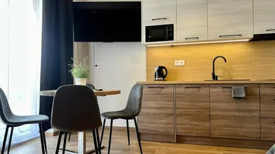 a kitchen with a counter with chairs and a sink at Rising Sun 3 by Housine,pl in Zator