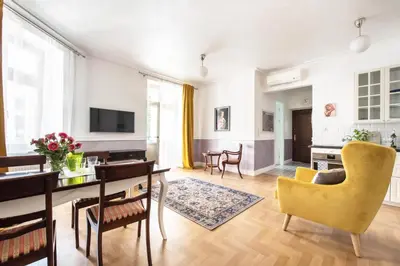 a living room with a table and a yellow chair at GROBLE 19 in Kraków