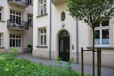 a large white building with a black door at GROBLE 19 in Kraków