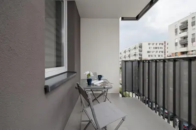 a balcony with a table and chairs on a building at Osiedle Avia Family Apartment in Kraków with Balcony by Noclegi Renters in Kraków
