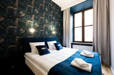 a bedroom with a blue and white bed with two pillows at Bracka Main Square Apartments in Kraków