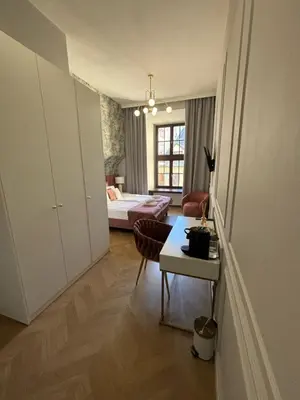 a living room with a table and a bedroom at Bracka Main Square Apartments in Kraków