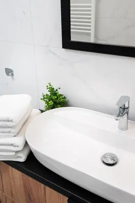a white bathroom sink with towels on a counter at City of the Kings-Poselska 24 in Kraków