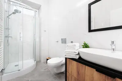 a white bathroom with a sink and a toilet at City of the Kings-Poselska 24 in Kraków