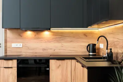 a kitchen with black cabinets and a black counter top at City of the Kings-Poselska 24 in Kraków