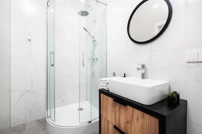 a bathroom with a sink and a shower with a mirror at City of the Kings-Poselska 24 in Kraków