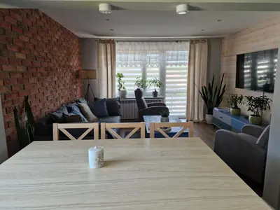 a living room with a table and a brick wall at Stefczyka 119 in Bachowice