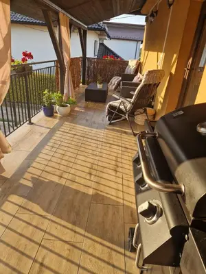 a patio with a grill and chairs on a deck at Stefczyka 119 in Bachowice