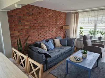 a living room with a couch and a brick wall at Stefczyka 119 in Bachowice