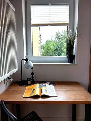 a desk with a book and a window at Royal Smart Apartments Cracow in Kraków