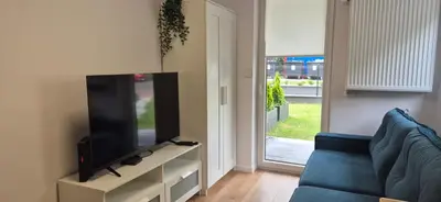 a living room with a blue couch and a flat screen tv at Royal Smart Apartments Cracow in Kraków