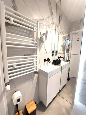 a white bathroom with a sink and a mirror at Royal Smart Apartments Cracow in Kraków