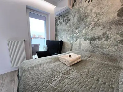 a bedroom with a bed with a bag on it at Royal Smart Apartments Cracow in Kraków