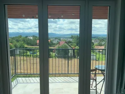 a view from a window of a balcony with a chair at Apartament Smile in Tomice