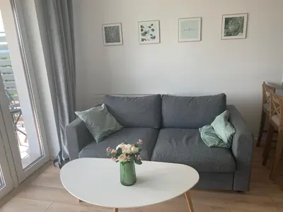a living room with a couch and a table at Apartament Smile in Tomice