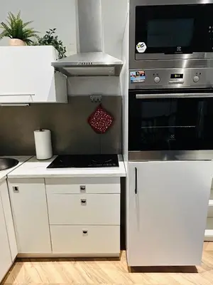 a kitchen with white cabinets and a stove top oven at Długa apartament in Kraków
