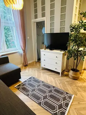a living room with a flat screen tv on a dresser at Długa apartament in Kraków