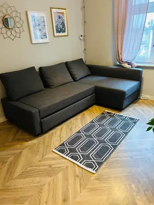 a black couch in a living room with a rug at Długa apartament in Kraków