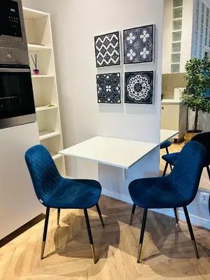a kitchen with two blue chairs and a table at Długa apartament in Kraków