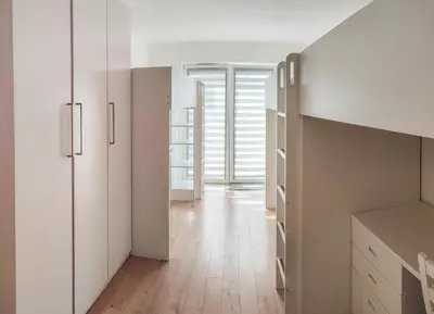 a kitchen with white cabinets and a wooden floor at Apartment Szwed-Sniadowskiej Residence in Kraków