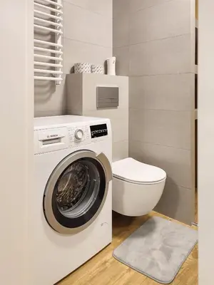 a bathroom with a washing machine and a toilet at Apartment Szwed-Sniadowskiej Residence in Kraków