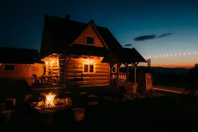 a log cabin lit up at night with lights at Górskie Tarasy in Rabka
